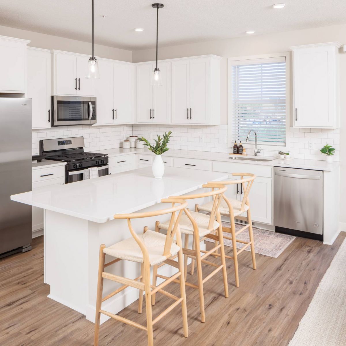 Olive Lane modern kitchen with white cabinets and countertops and wood floors